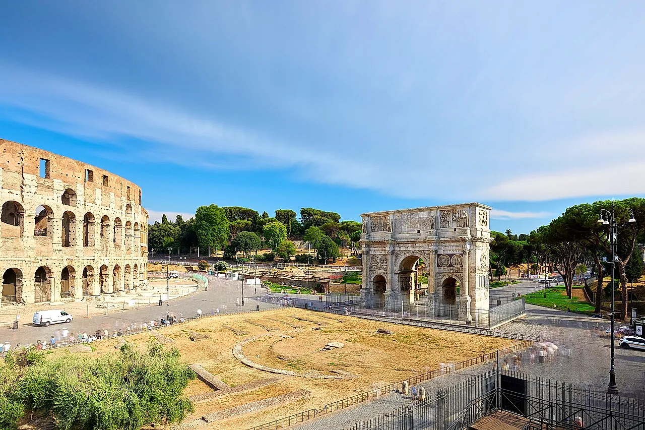 The Colosseum and the Arch of Constantine under a clear blue sky