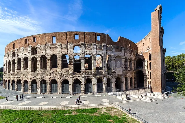 The outer wall of the Colosseum on the east side, with the brick buttress, under a blue sky