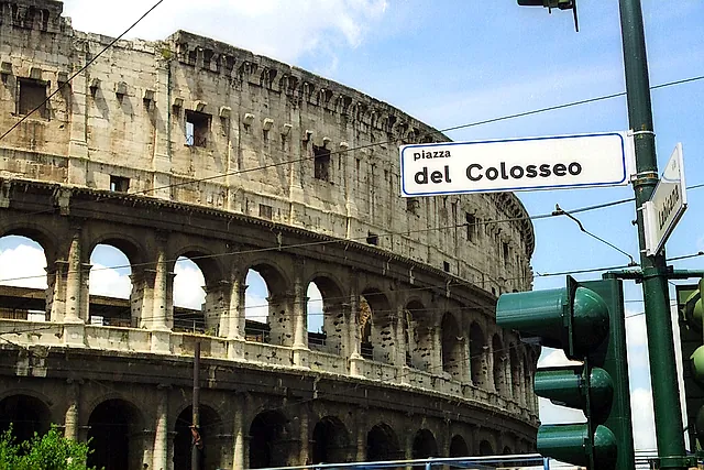 The Colosseum's outer arcades seen from Piazza del Colosseo, with the street sign for the square