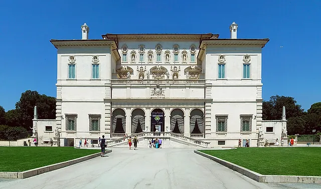 The façade of the Galleria Borghese in the gardens of Villa Borghese, under a blue sky